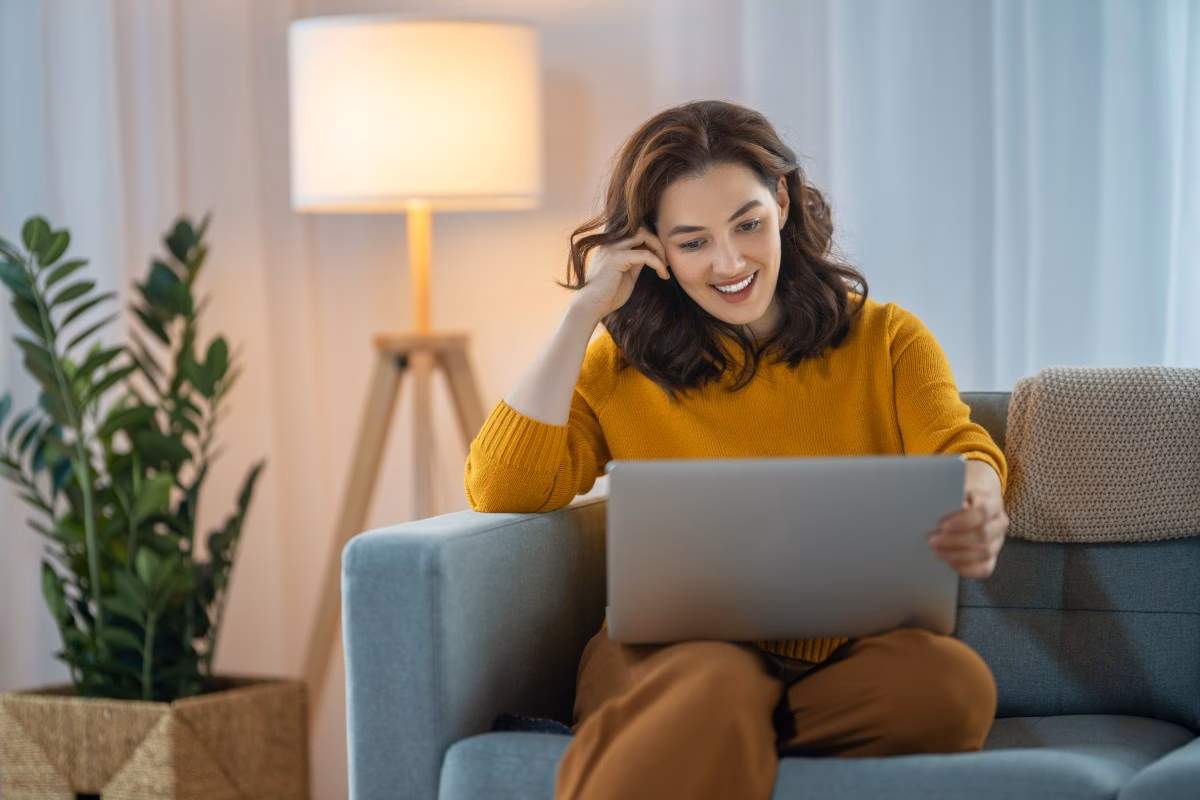 Frau sitzt vor dem Laptop, um Fragen zum kostenfreien Online-Infoabend zu klären